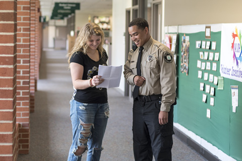 Big Thinker - Clinton Keene Clinton talking with student in his Public Safety uniform.
