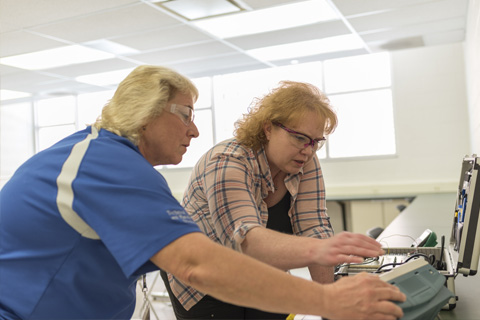 Big Thinker - Heather Radick Heather working with her instructor on an electrical training box.