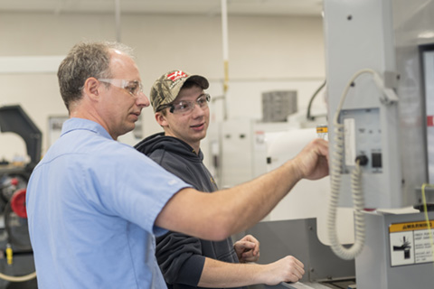 Big Thinker - Logan Searfoss Logan working with an instructor in the CNC lab.