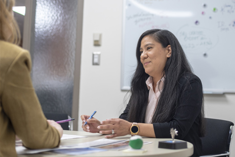 Big Thinker - Monica Corriveau Monica speaking in a meeting.