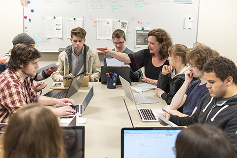 The Collegiate staff working around a table in the news room.