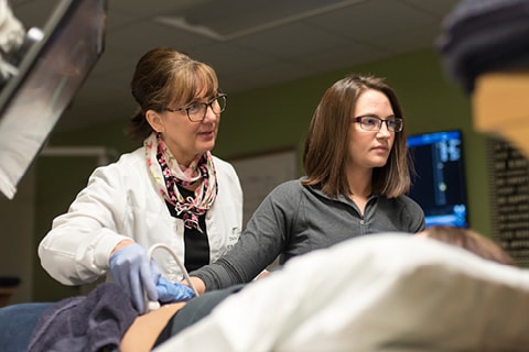 Sonography Faculty with a student working in the lab.