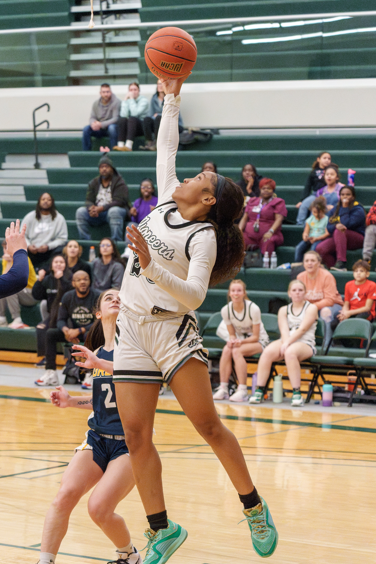 Delta College Women's basketball player jumps for ball on the court