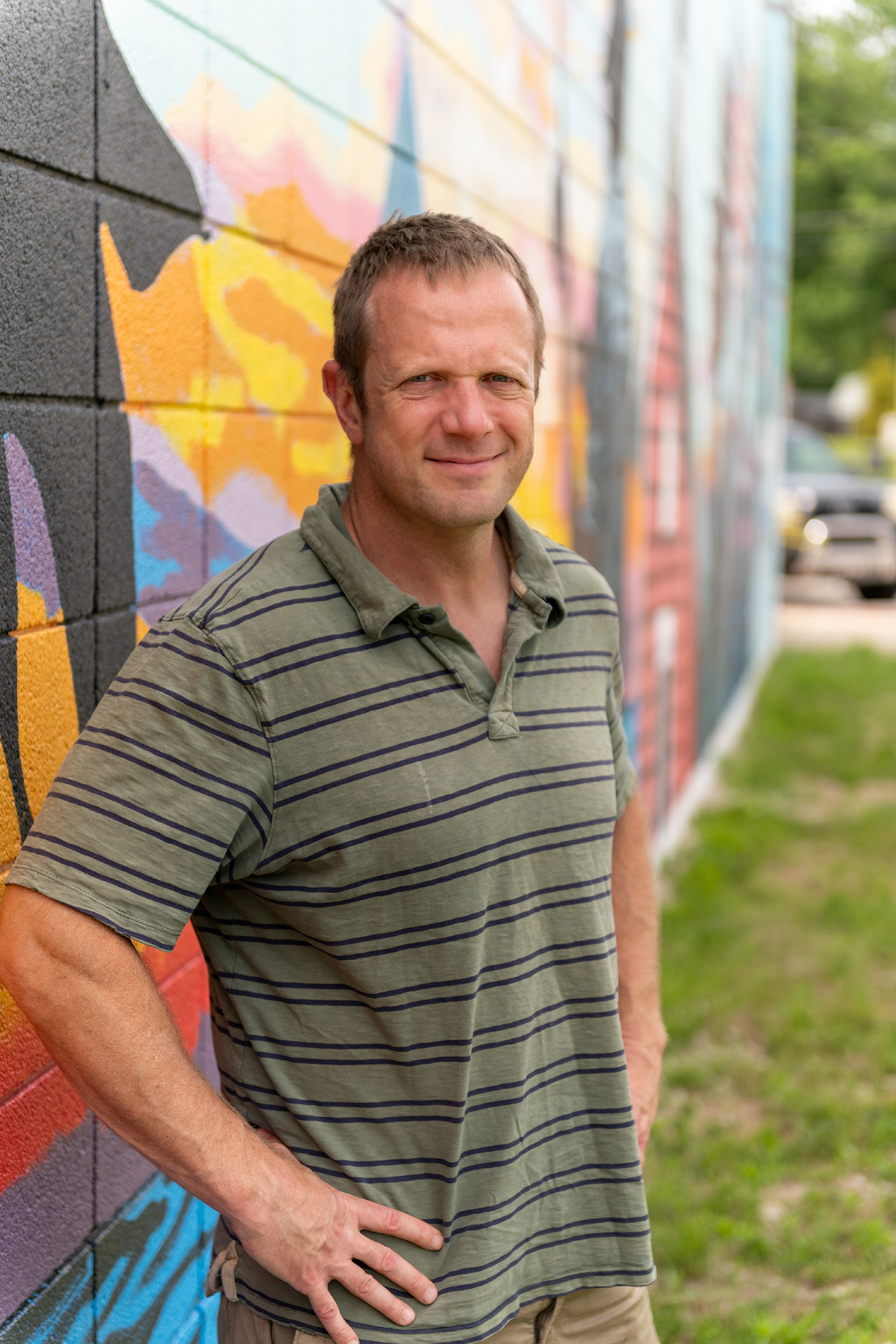 Andrew Reider in front of mural