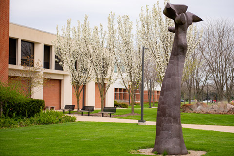 Delta College main campus exterior white floral trees green grass and tall grey sculpture