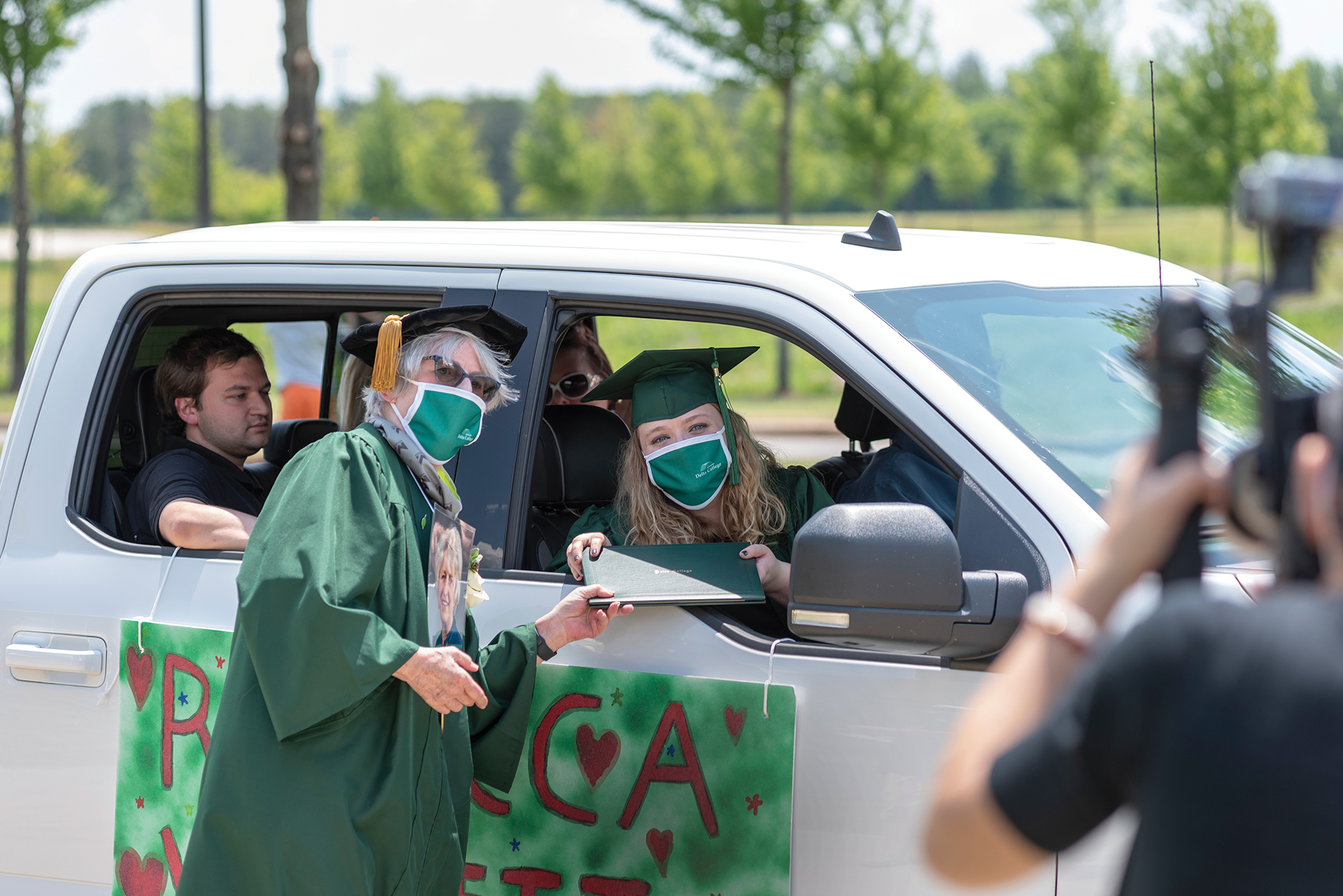 Dr. Goodnow giving diploma to student in car