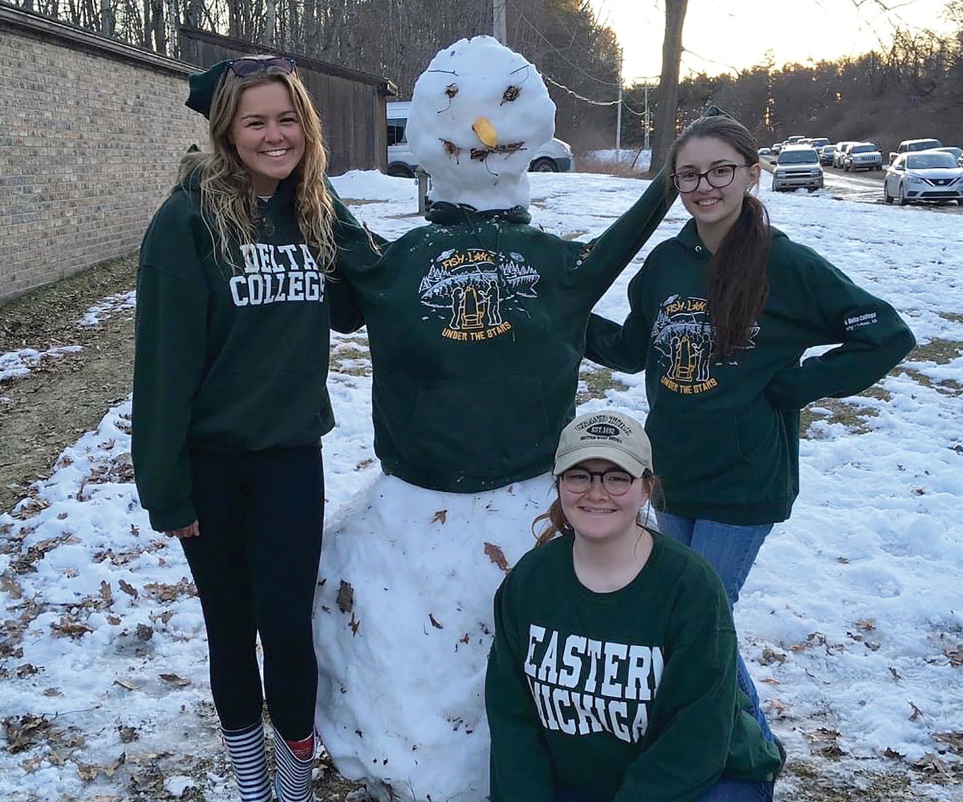 Sydney Hollis building a snowman with classmates