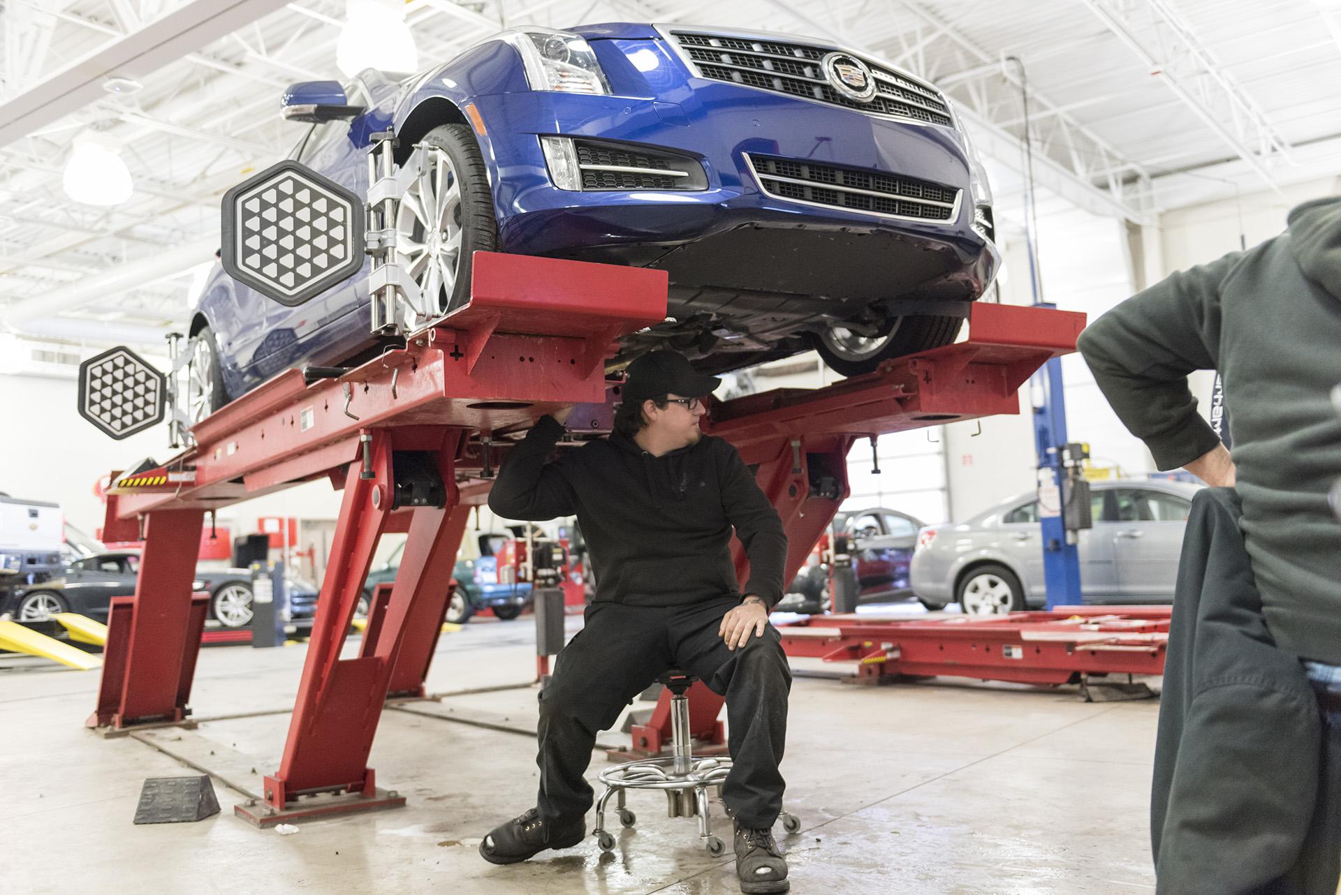 A student evaluates a car in the automotive lab.