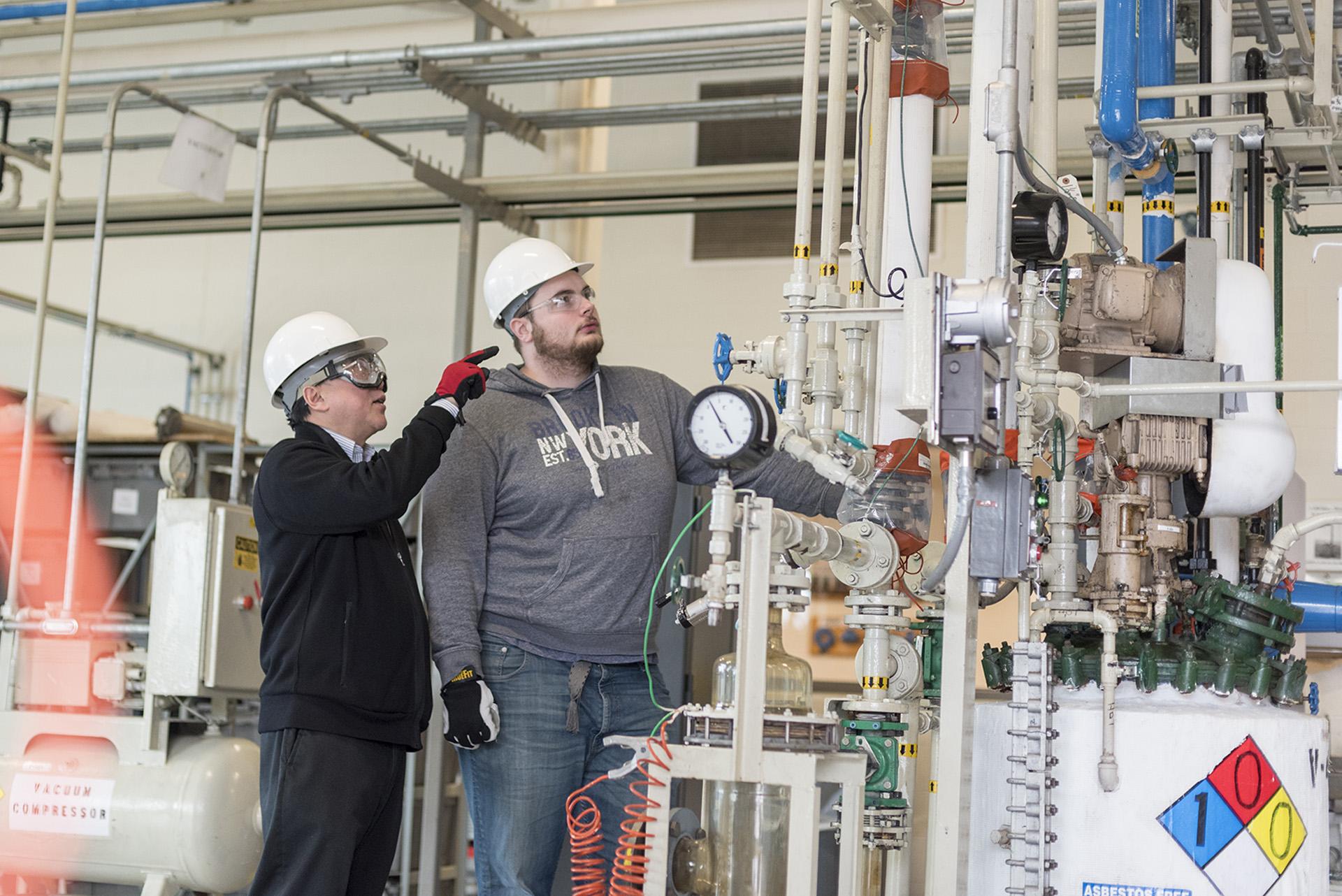 A student, right, in training at the chemical process technology lab to become a production operator.