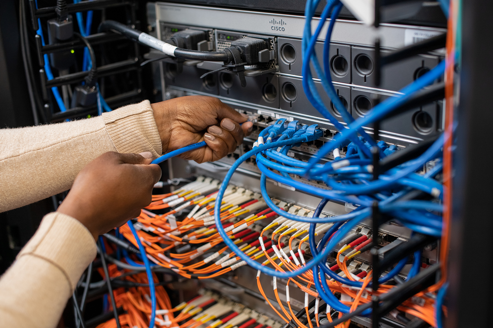 Student's hands working in the networking lab.