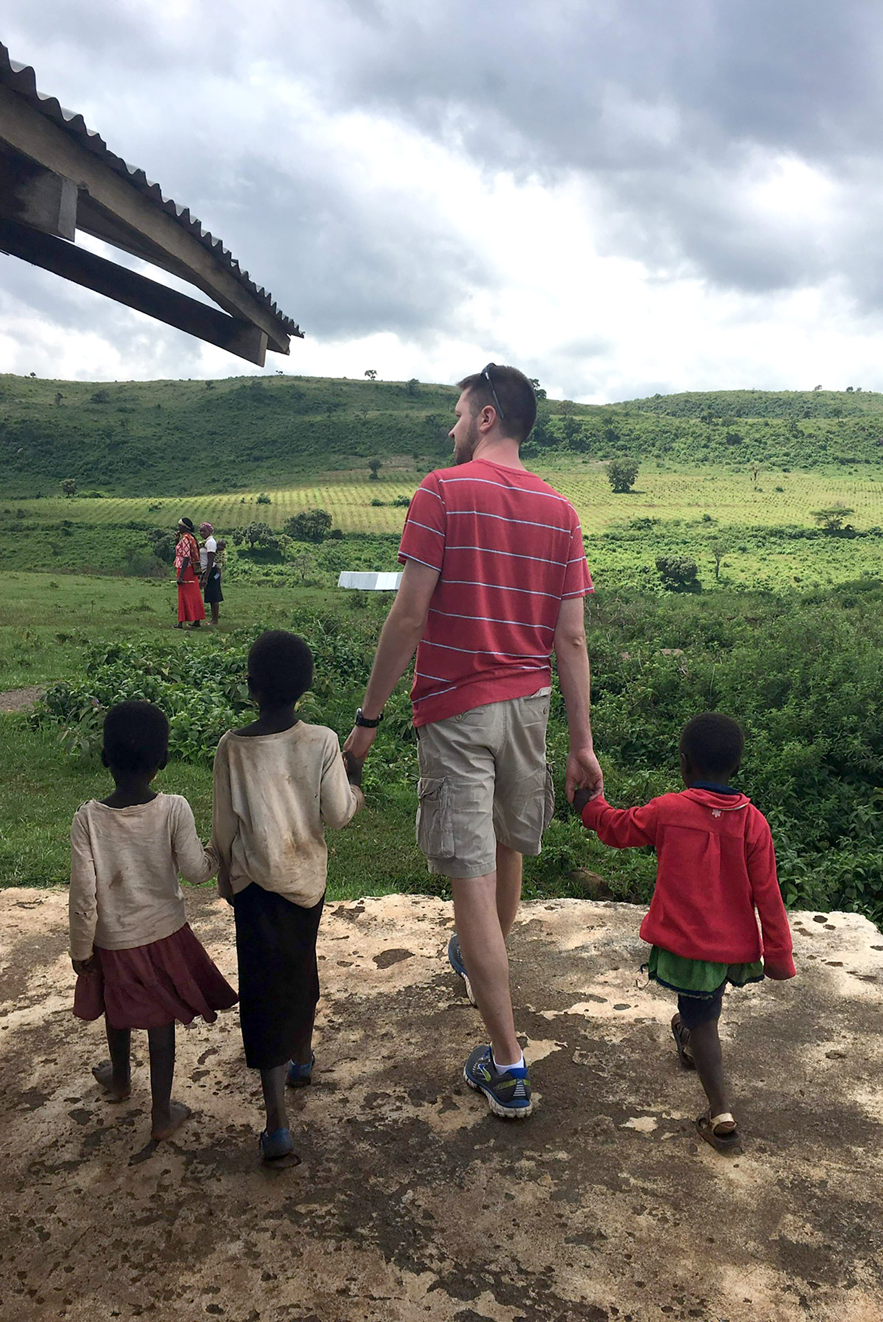 A Delta student walking with Kenyan children